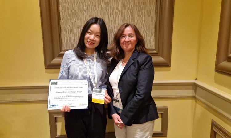 Ph.D. candidate Jingyuan Zhang (left) receiving the LCN Best Paper award.