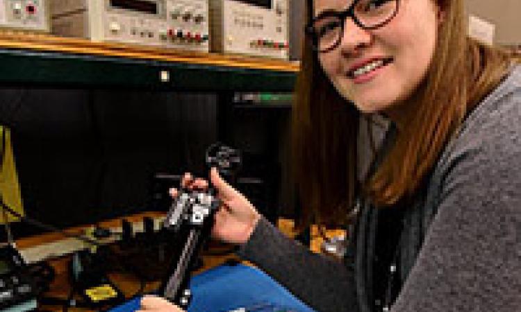 Electrical engineering major Amanda Remus holds a leg brace from the Smart Wheelchair.