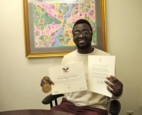 Olatide Omojaro, with his President's Volunteer Service Award.